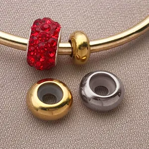 Detalle macro de cuentas espaciadoras chapadas en oro y plata con anillos de silicona