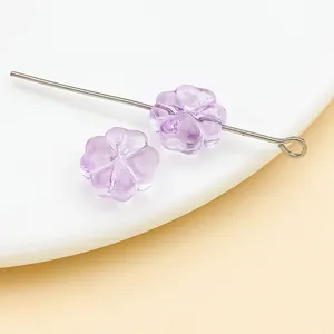 Primer plano de cuentas de vidrio morado de 10 mm con forma de flor para bisutería DIY.