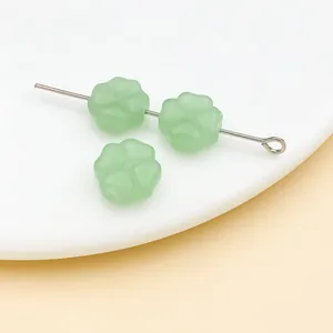 Vista macro de cuentas de vidrio de trébol verde claro de 10mm para accesorios de joyas