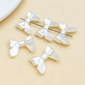Nahaufnahme von cremeweißen Schleifenperlen mit Perlmuttglanz für DIY-Schmuck.