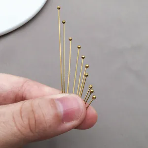 Detailed close-up of gold stainless steel ball head pins for DIY jewelry making crafts