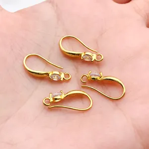 Close-up macro view of four 18k gold plated earring hooks with clear zircon insets