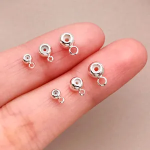 Detalle de cuentas de posicionamiento de silicona plateadas con ojal para joyería DIY