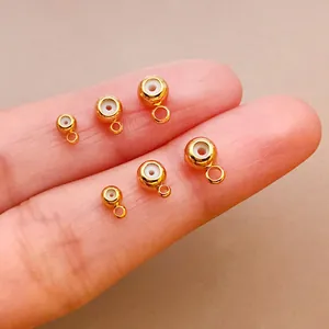 Primer plano de cuentas de tope de silicona doradas con bucles para joyería DIY.