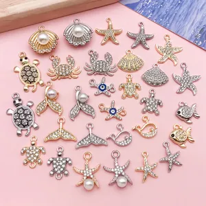 Assorted gold and silver ocean themed charms with rhinestones and pearls for DIY necklaces.