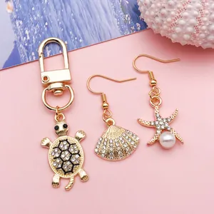 Detail of gold ocean-themed charms including rhinestone turtle, shell and starfish