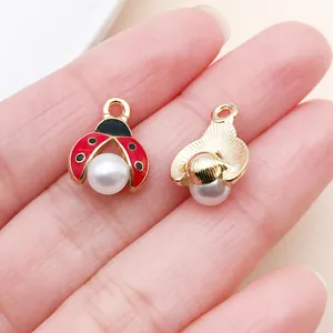 Detailansicht von Marienkäfer-Emaille-Anhängern mit weißen Perlen für DIY-Schmuck