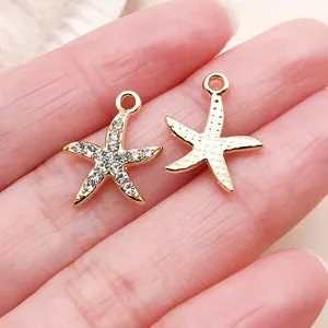 Close-up of gold starfish charms with rhinestones and textured back for DIY jewelry.