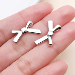 Primer plano de dos colgantes de lazo hueco en tono plateado para joyería de bricolaje