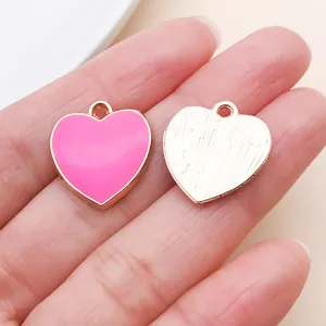 Dettaglio dei ciondoli a cuore in lega oro rosa con smalto rosa e retro strutturato
