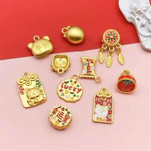 Detailed view of colorful enamel lucky cat and cookie gold charms for DIY jewelry.