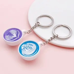 Close-up of miniature resin coffee cup charms with heart and swan latte art patterns