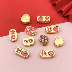 Makroansicht von chinesischen Goldperlen mit roten Emaille-Glückszeichen für DIY