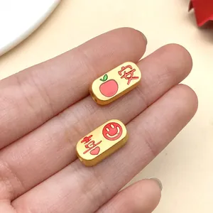 Detailansicht goldener Emaille-Zwischenperlen mit chinesischen Schriftzeichen