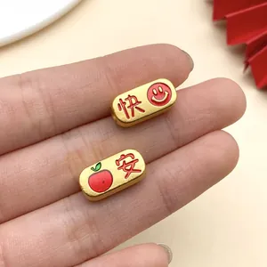 Detaillierte Nahaufnahme goldener chinesischer Perlen mit roter Emaille für DIY-Schmuckarmbänder