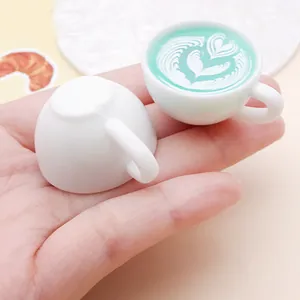 Detailed view of miniature resin coffee cup with mint green heart latte art pattern