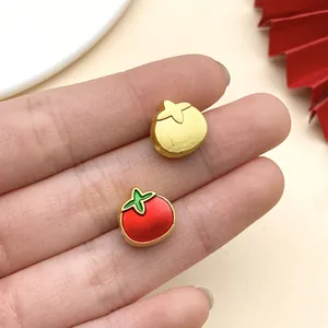 Nahaufnahme von roten Emaille- und Goldtomaten-Großlochperlen für DIY-Schmuck