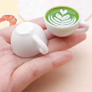 Close-up of a miniature resin coffee cup featuring a detailed heart latte art pattern