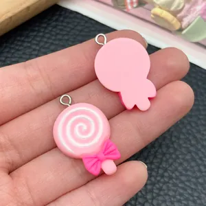 Detailed macro view of pink bow lollipop resin charms showing front and back textures