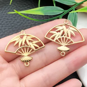 Macro detail of golden bamboo leaf fan charms for DIY jewelry and hair accessories