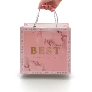 Roze bloemen cadeautas met gouden BEST letters en gedraaide koordgrepen