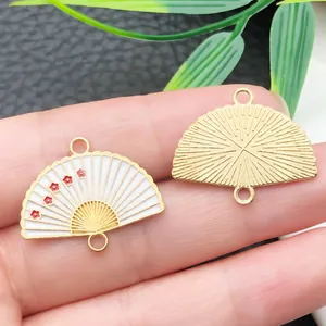Macro detail of Chinese style gold fan charms featuring white enamel and plum blossom