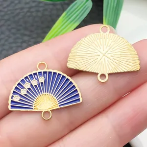 Close-up of blue enamel fan charm and gold alloy back with plum blossom details for DIY.