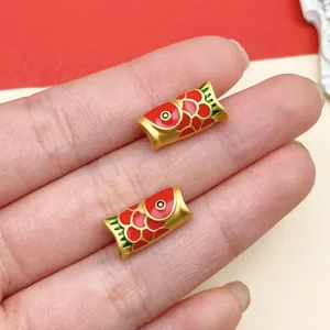 Ripresa macro di ciondoli carpa koi in oro opaco con smalto rosso per la creazione di gioielli