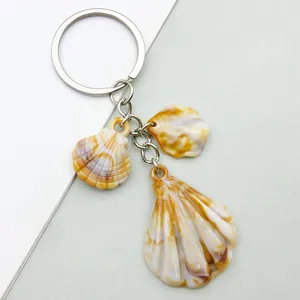 Detailed macro view of amber patterned acrylic shell charms on a silver metal keychain
