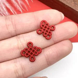 Primer plano de dos colgantes de nudo chino rojo mate para creación de joyas DIY