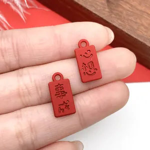 Detalle de pequeños dijes rectangulares rojos con caracteres chinos en relieve