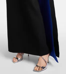 Primer plano de vestido largo azul con sandalias de tacón alto plateadas metalizadas.