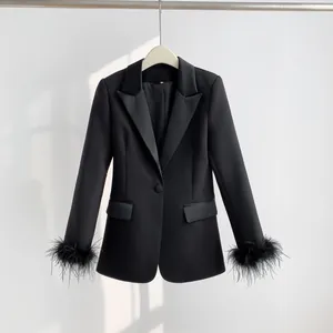 Detailed view of black women's blazer featuring stylish feather trim on the cuffs