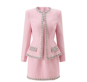 Detailed front view of pink tweed jacket and skirt set featuring sparkling crystal trim.