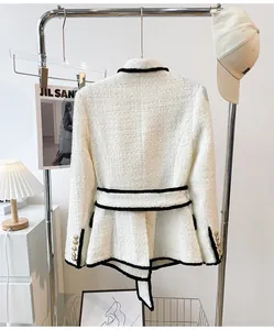 Elegant white tweed jacket with black trim and belt for a sophisticated urban look.
