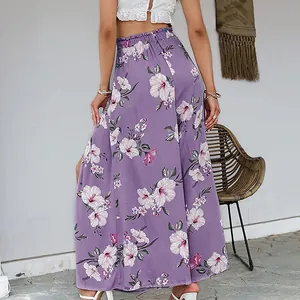 Close-up of vibrant purple hibiscus floral print and high side slit detail on flowy wide-leg pants