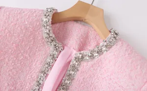 Close-up detail of a pink tweed jacket collar featuring crystal and sequin embellishments