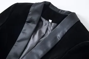 Detailed macro view of a black velvet blazer featuring a satin shawl collar and lining.