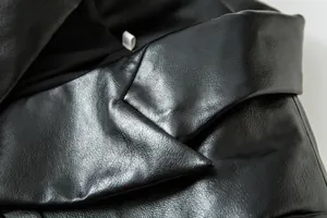 Vista detallada de la textura de cuero sintético negro de calidad en este cuello de chaqueta