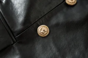 Primer plano de botones dorados con cabeza de león en una chaqueta de cuero sintético negro