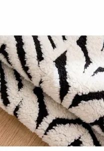 Macro dettaglio che mostra la morbida trama del tessuto felpato zebrato bianco e nero per animali