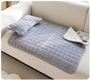 Détail d'un tapis en peluche matelassé gris pour animaux avec oreiller assorti sur sofa