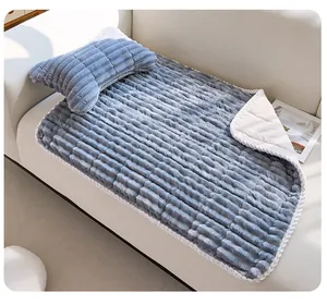 Dettaglio di qualità di un set di coperta in peluche blu grigio e cuscino a osso