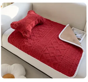 Gros plan d'une couverture rouge pour animaux avec bord tressé blanc et oreiller assorti