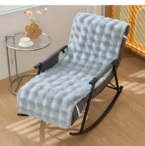 Détail d'un coussin en peluche bleu doux placé sur une chaise à bascule classique en bois