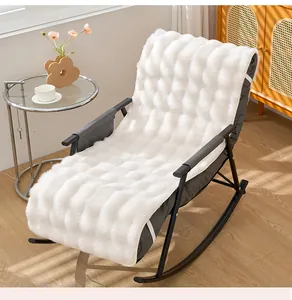 Gros plan détaillé d'un coussin en velours blanc texturé posé sur une chaise à bascule noire