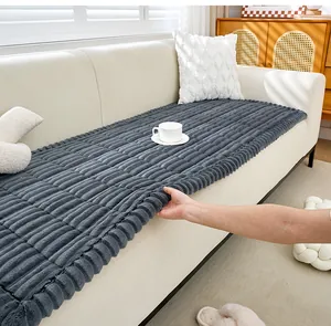 Détail d'un coussin de canapé en peluche gris épais montrant le bord du tissu texturé