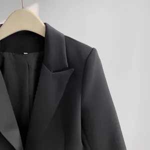Close-up detail of a professional minimalist black blazer lapel and fabric texture