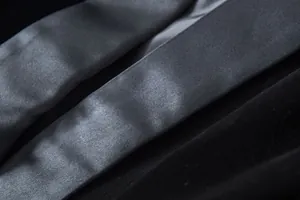 Detailed macro view of high-end gold velvet fabric and shiny satin lapel of a blazer jacket