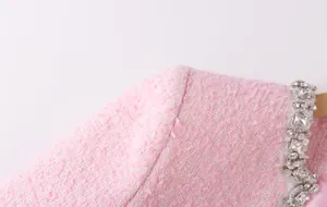 Close-up view of pink tweed jacket shoulder with luxury crystal rhinestone neckline